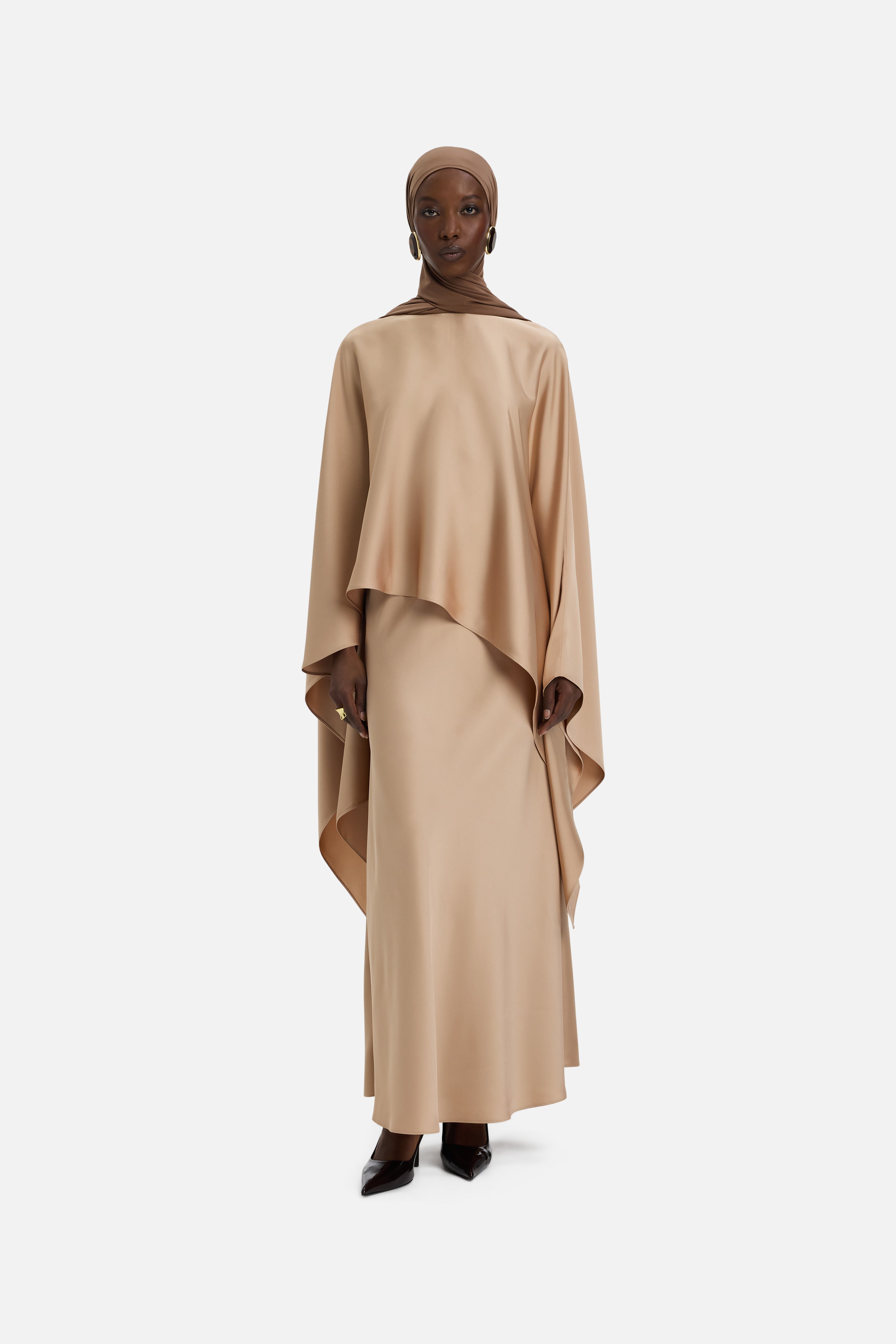 Front view of model wearing light brown asymmetric blouse