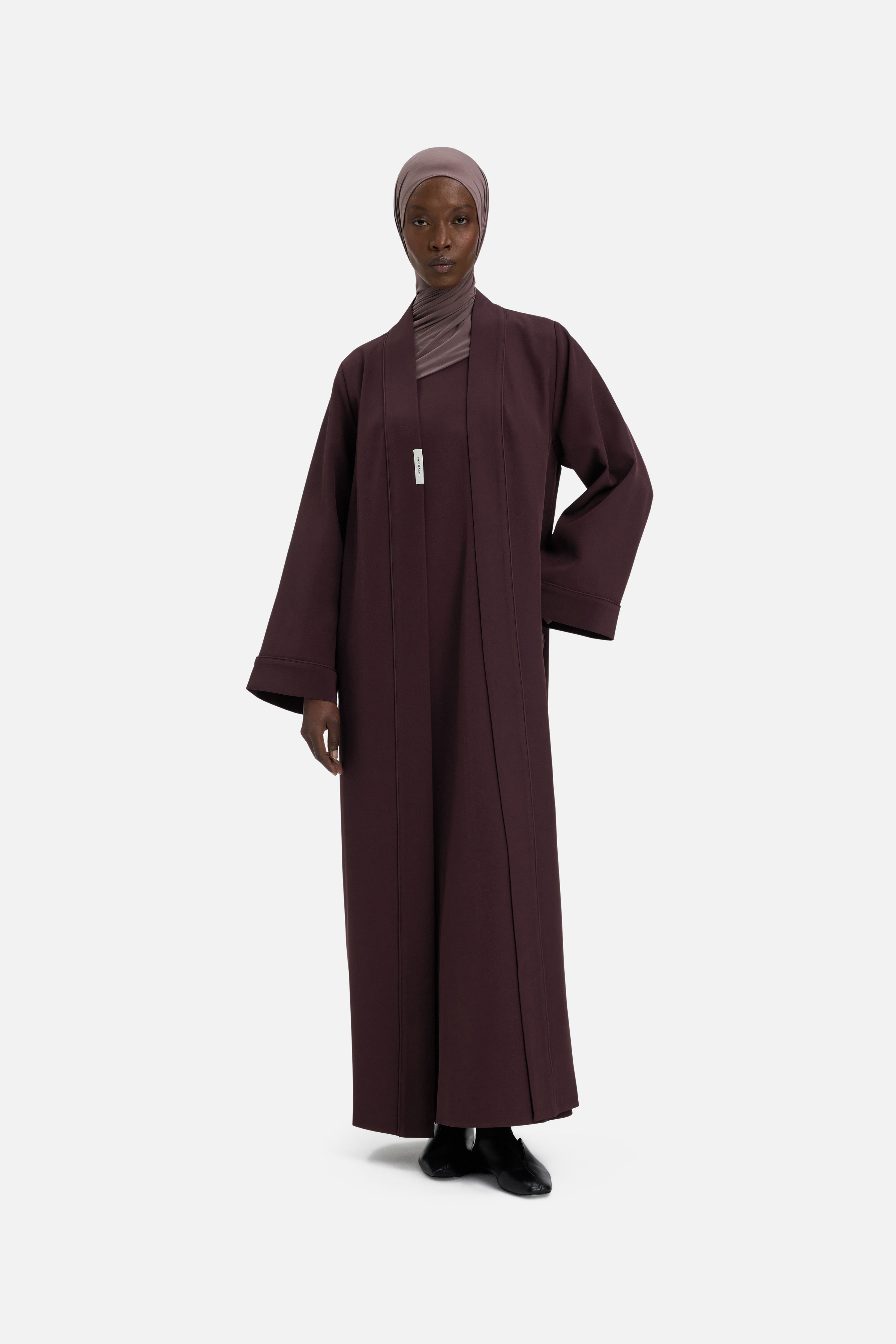 Model wearing purple abaya and headscarf, front view