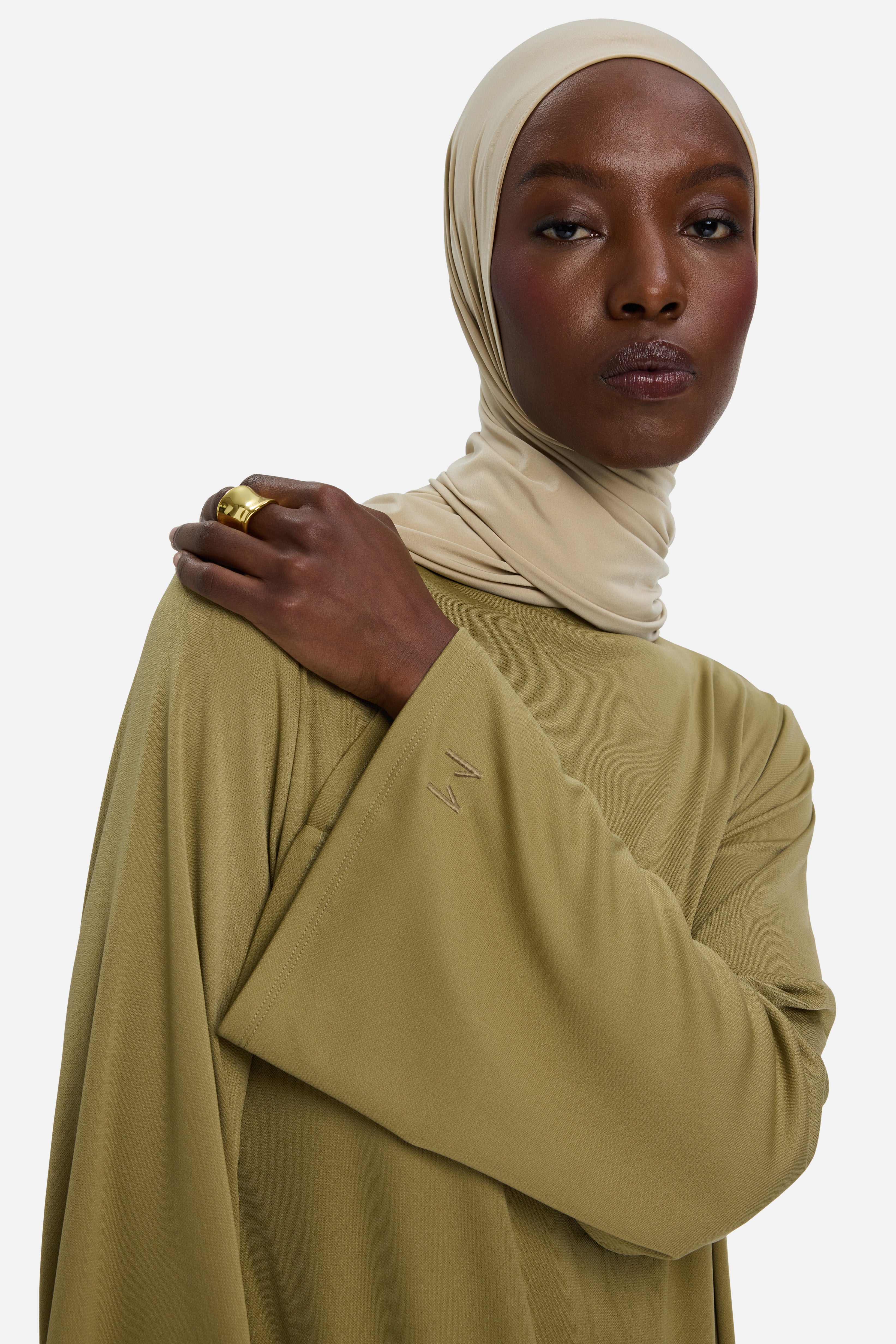 Close up model wearing green dress and headscarf