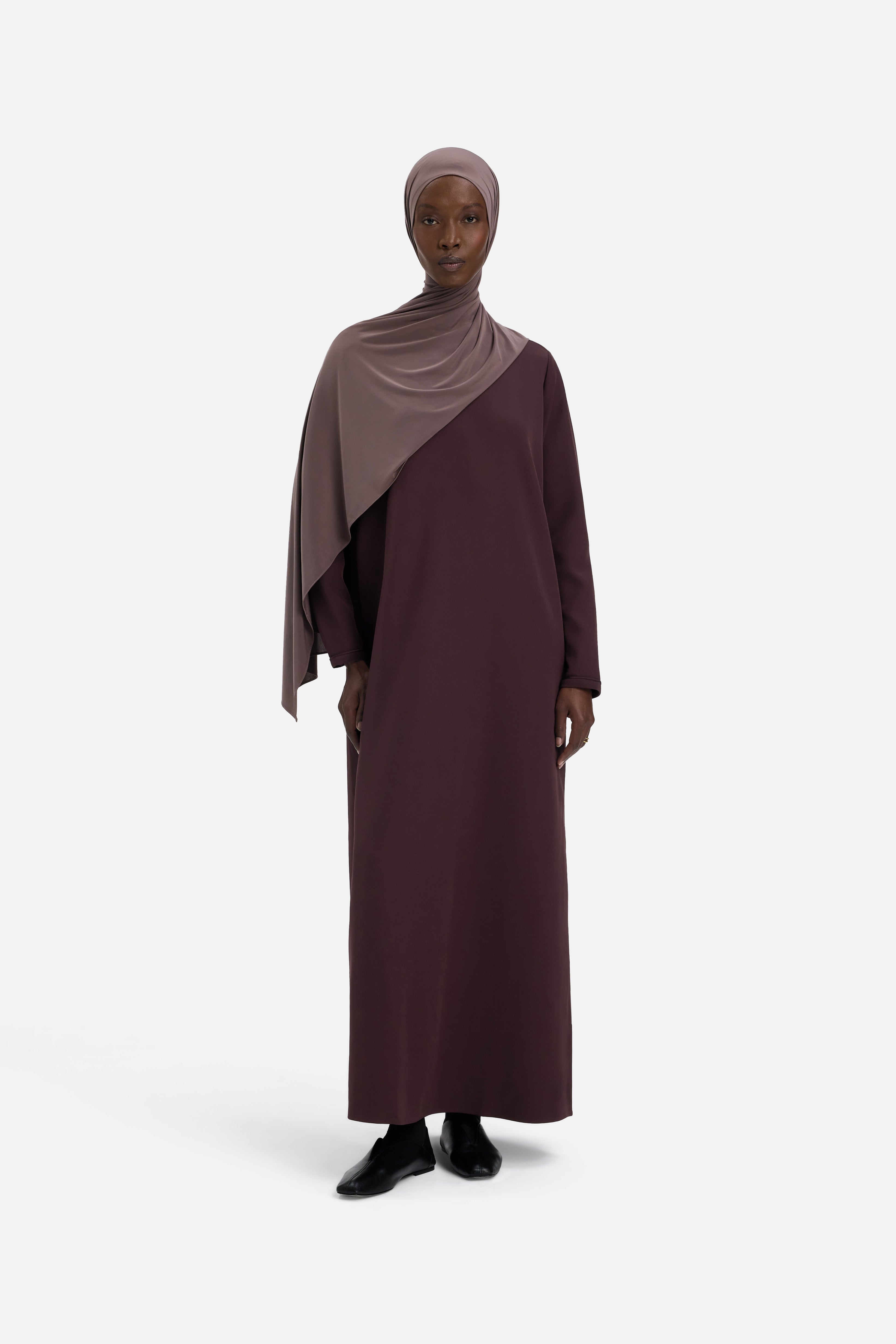 Model wearing purple dress and headscarf, front view