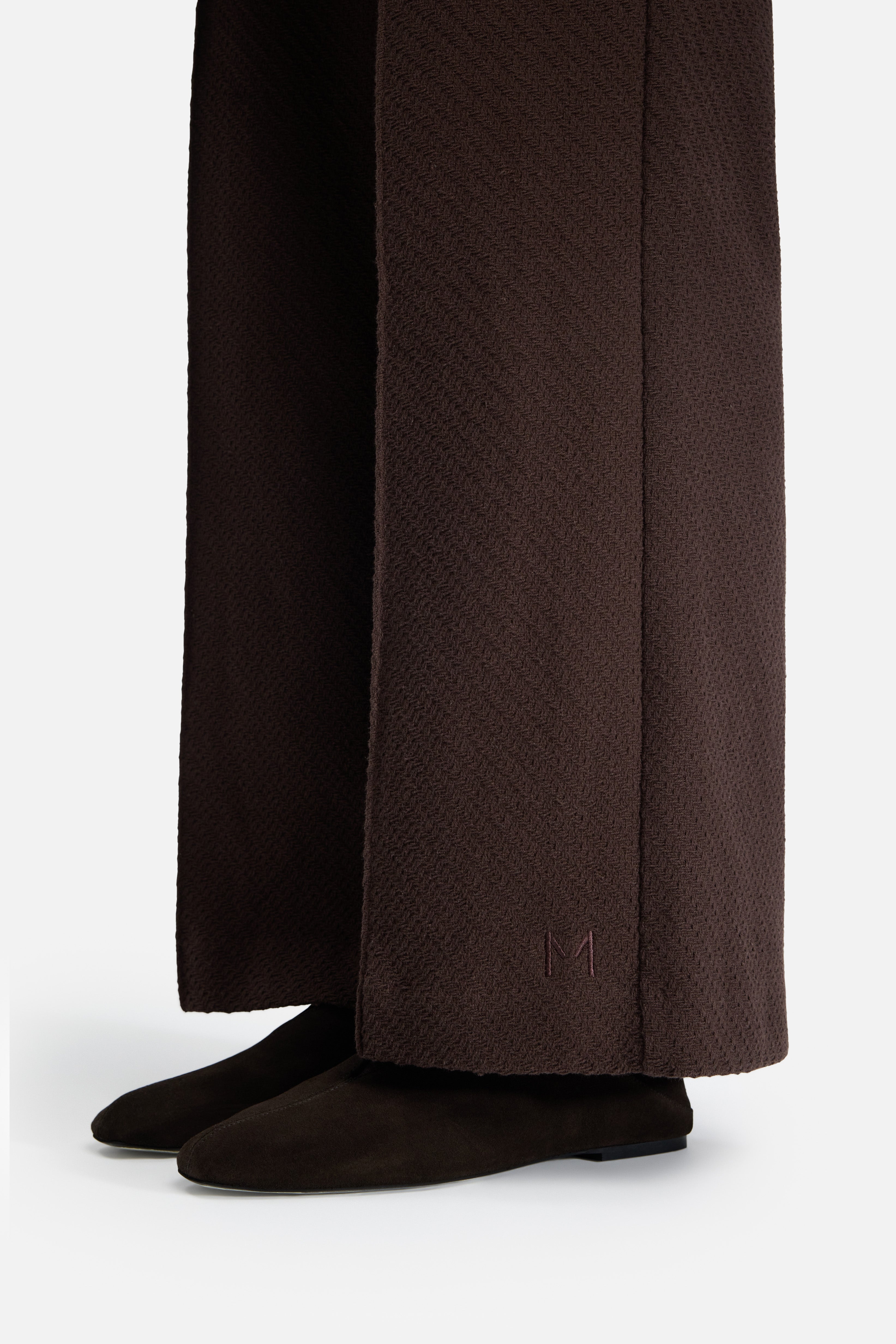 Detail side view model wearing brown pants