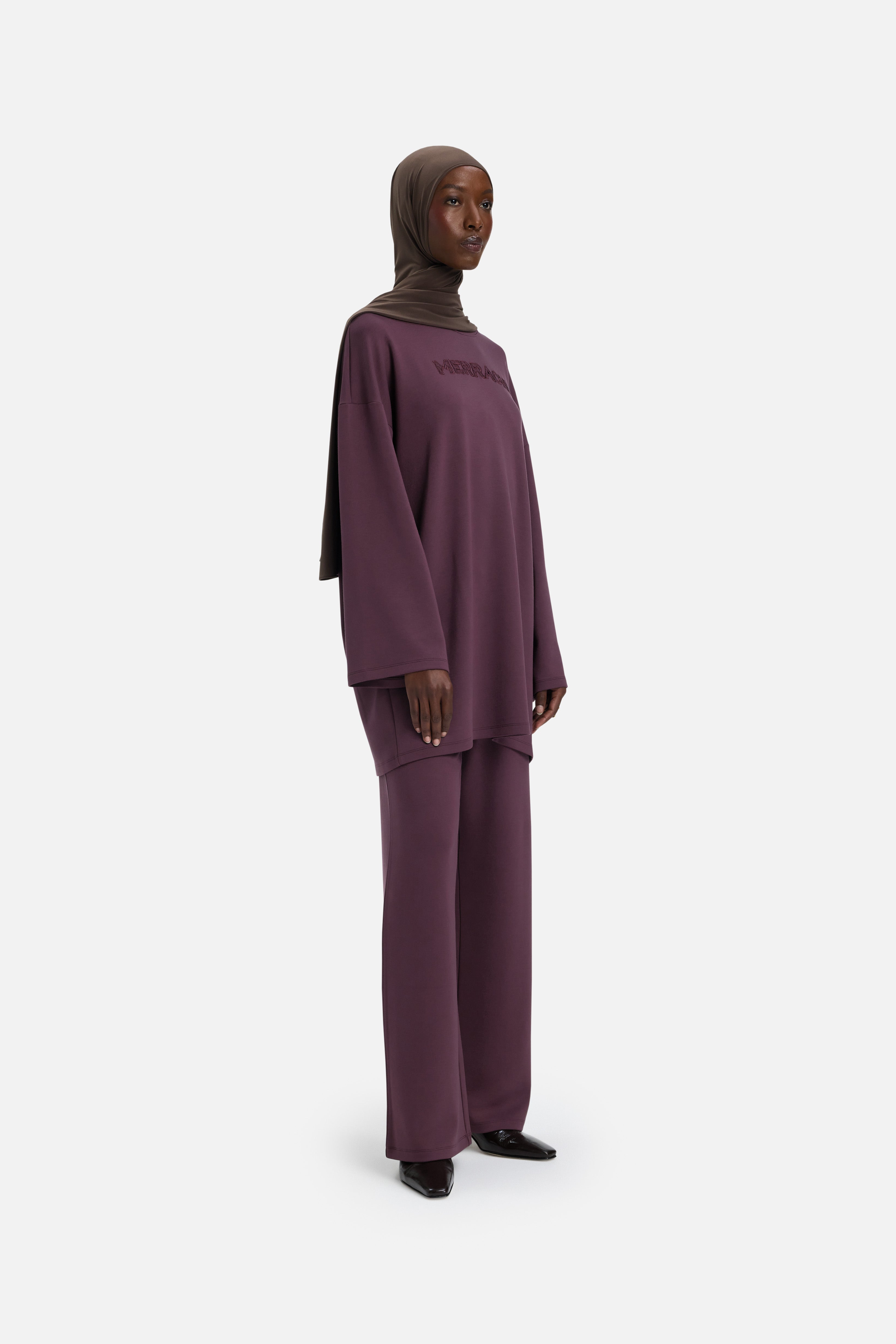 Model wearing purple MERRACHI pants, side view
