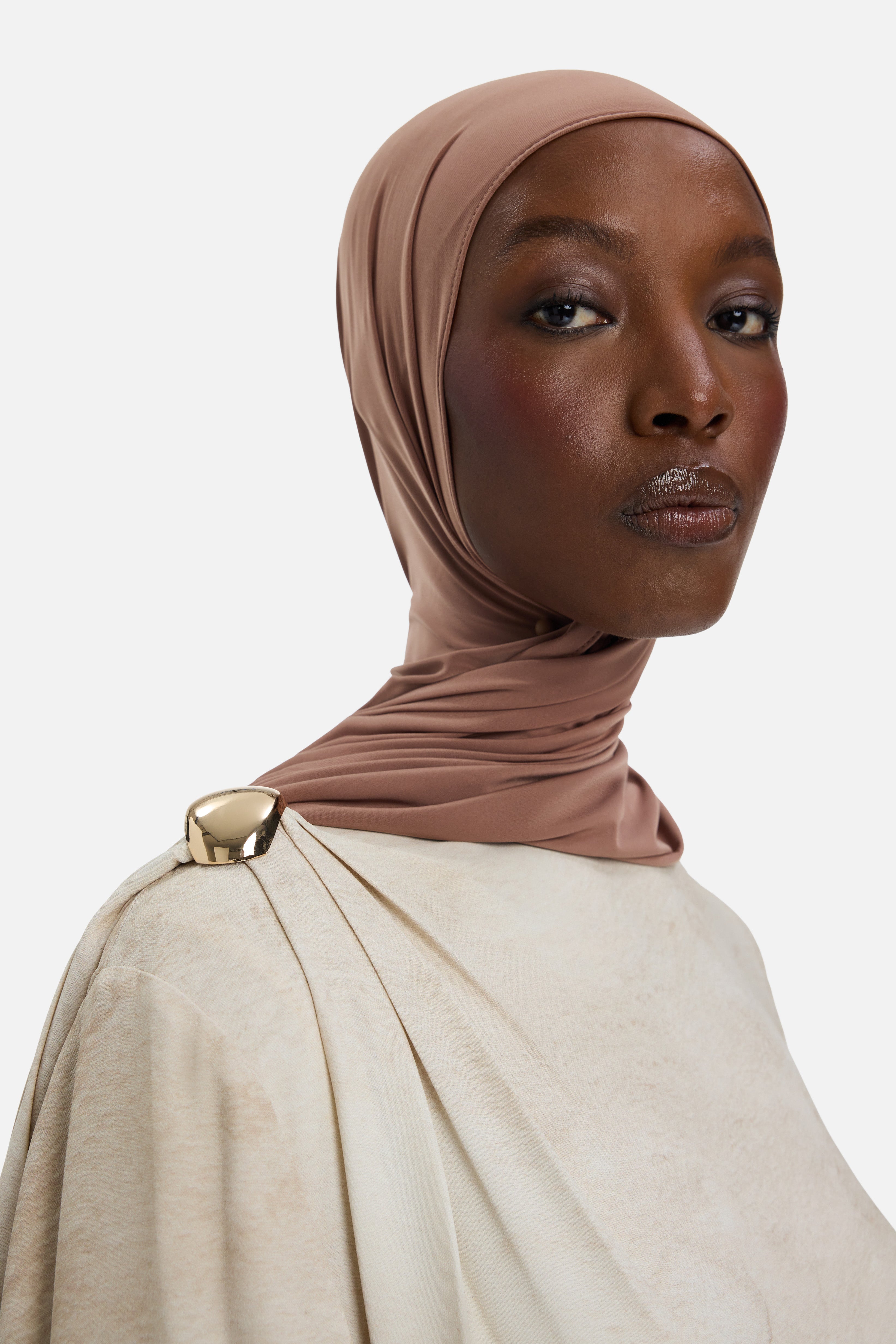 Detail view model wearing off white dress with gold buckle on shoulder