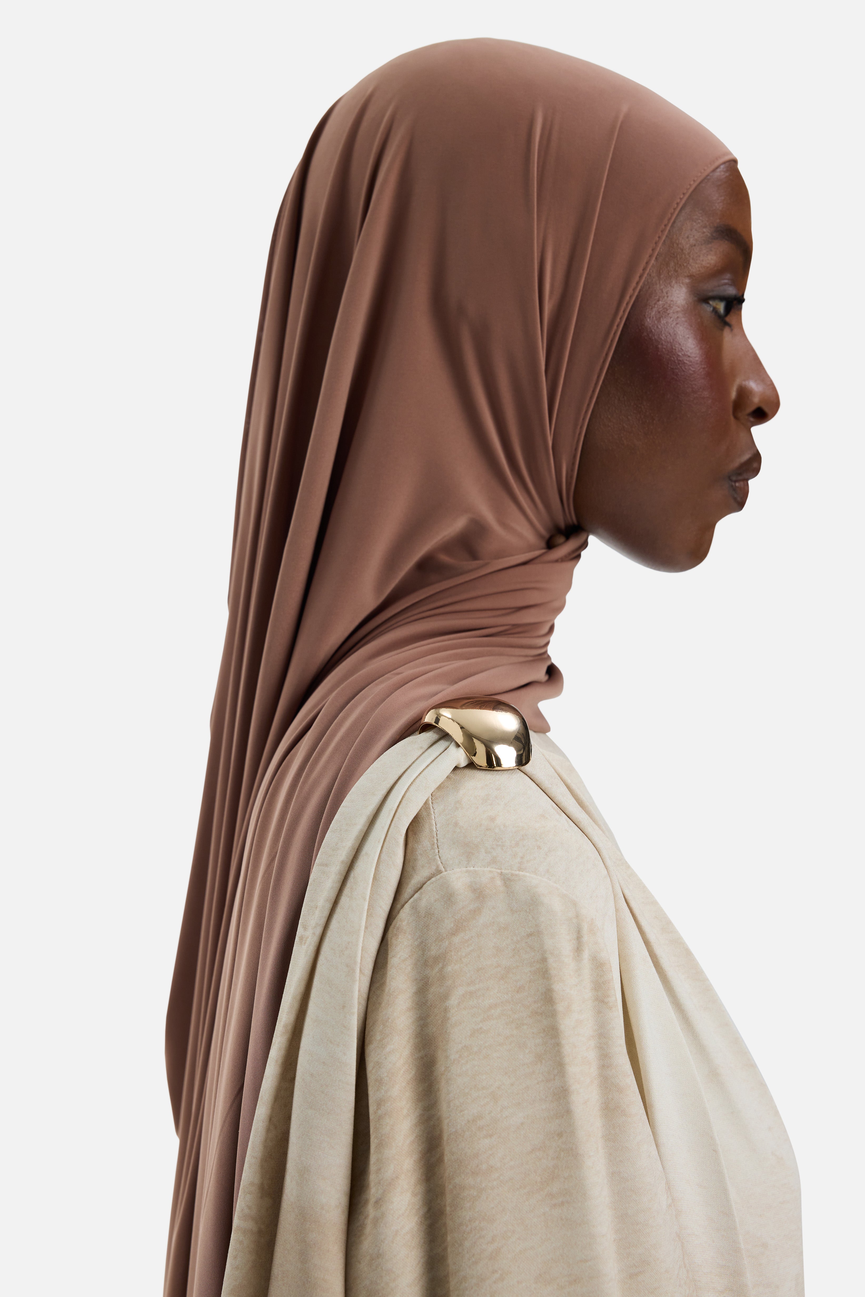 Side view model wearing off white dress with gold buckle detail on shoulder