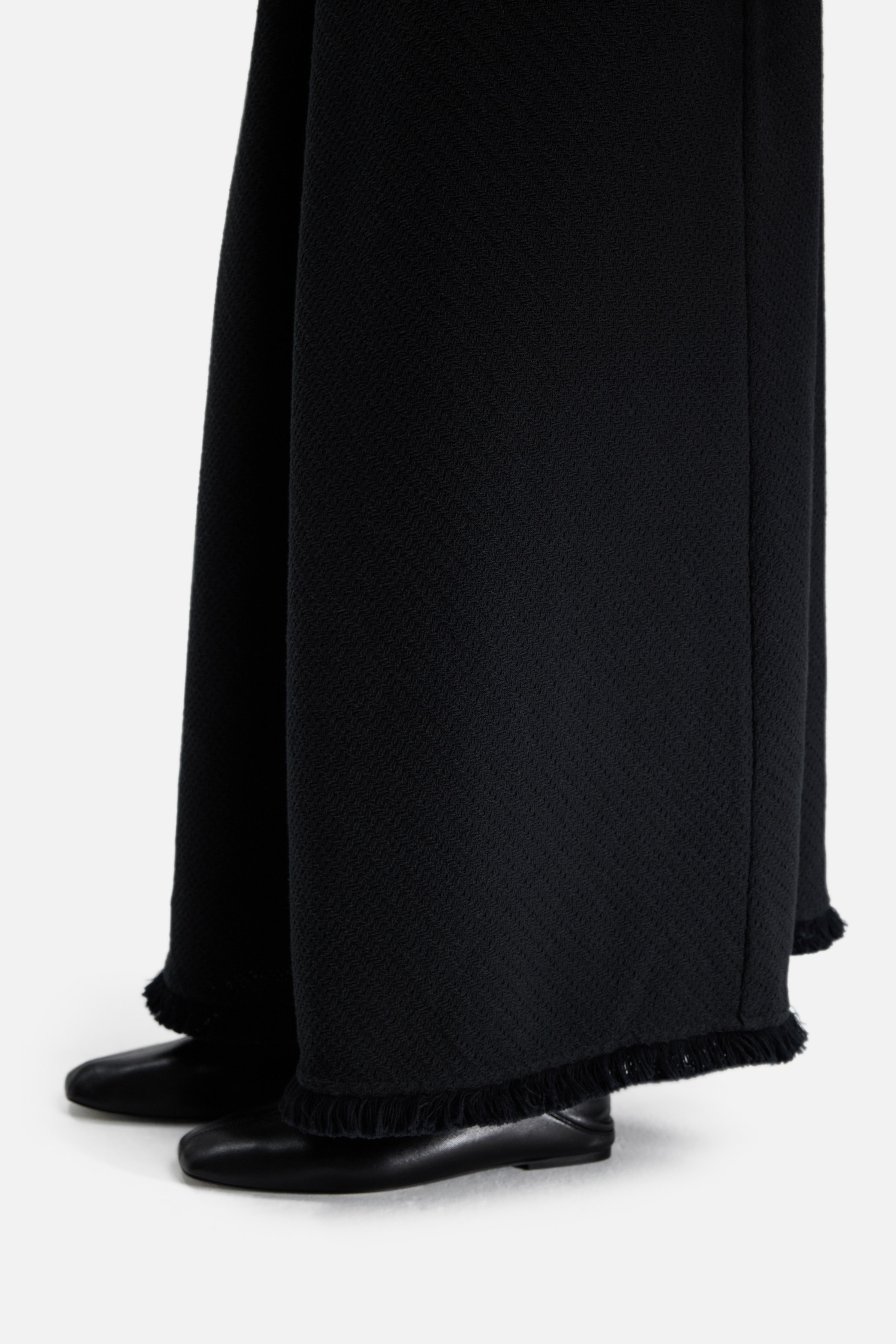 Close up fringe bottom of black dress