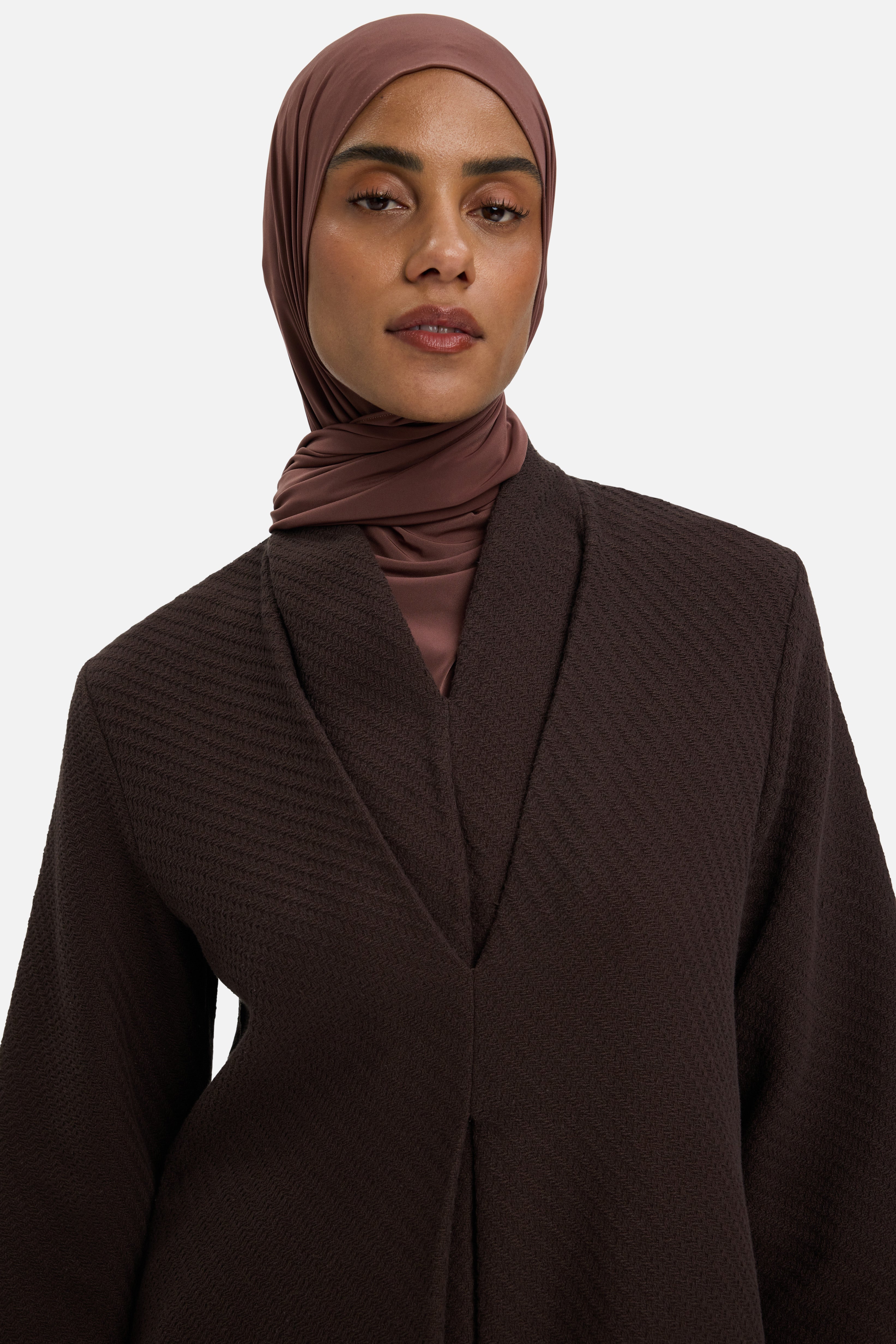 Detail shot model wearing brown top and headscarf