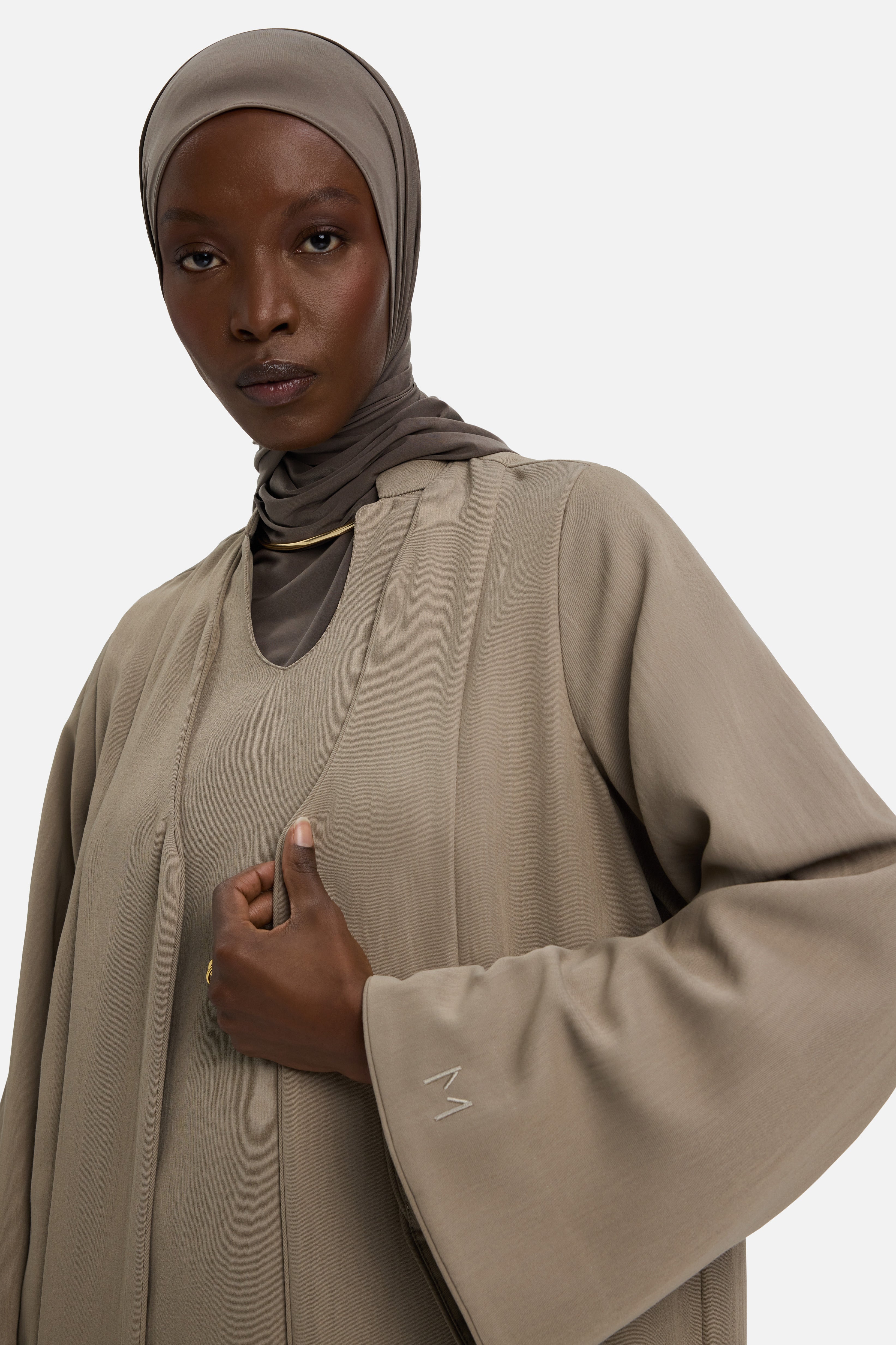 Detail view model wearing khaki abaya and grey headscarf