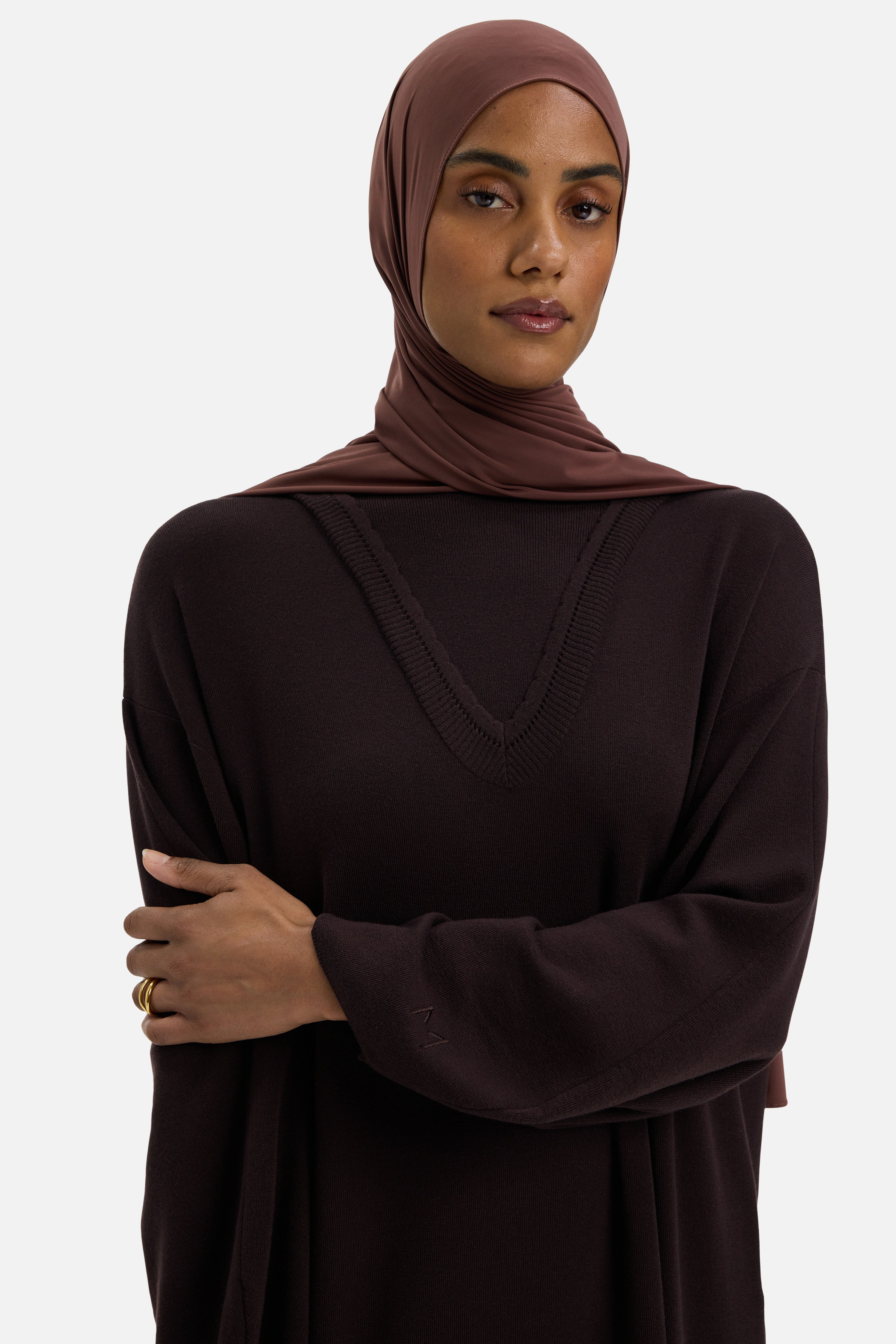 Detail view model wearing brown dress and headscarf