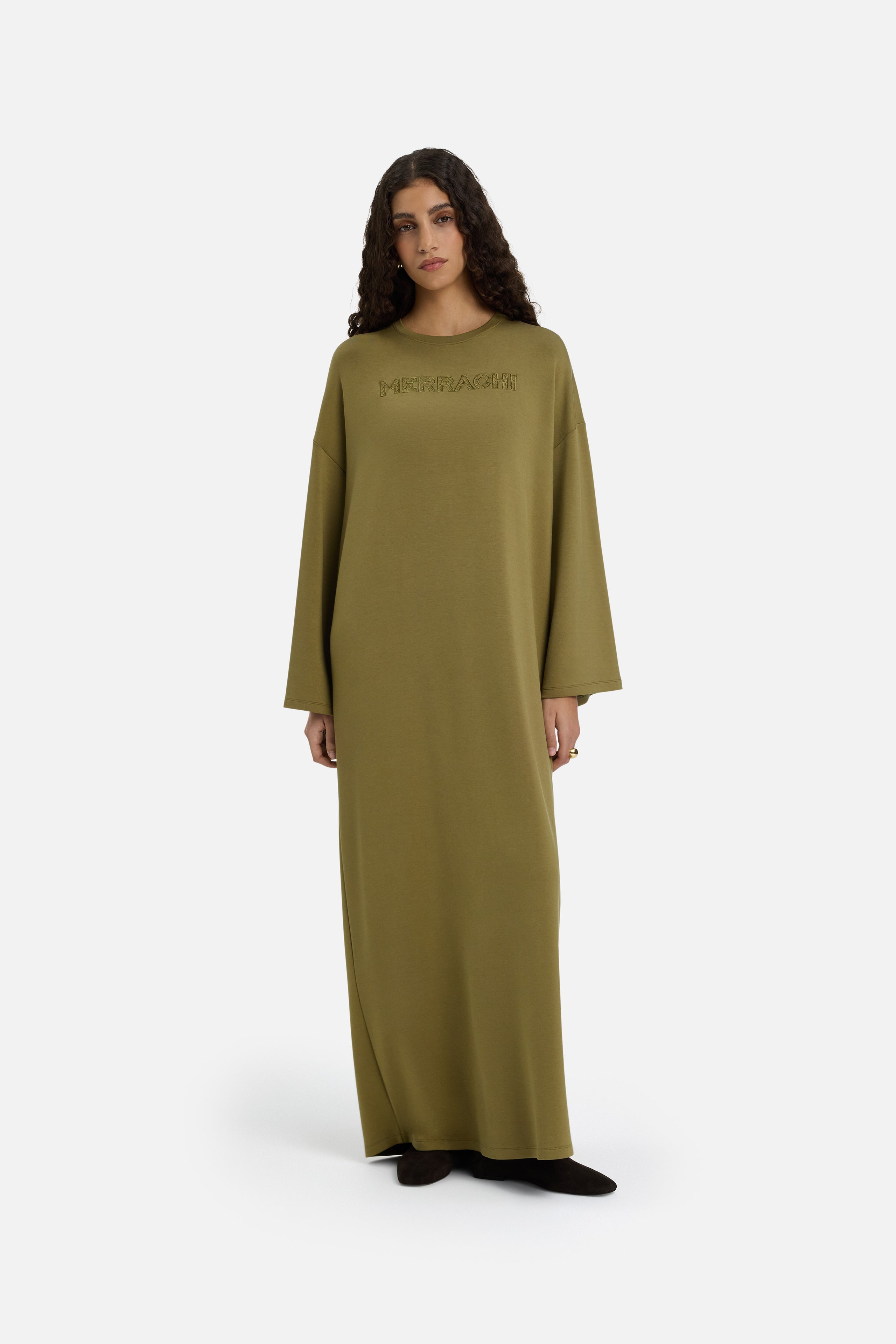 Model wearing green MERRACHI dress, front view