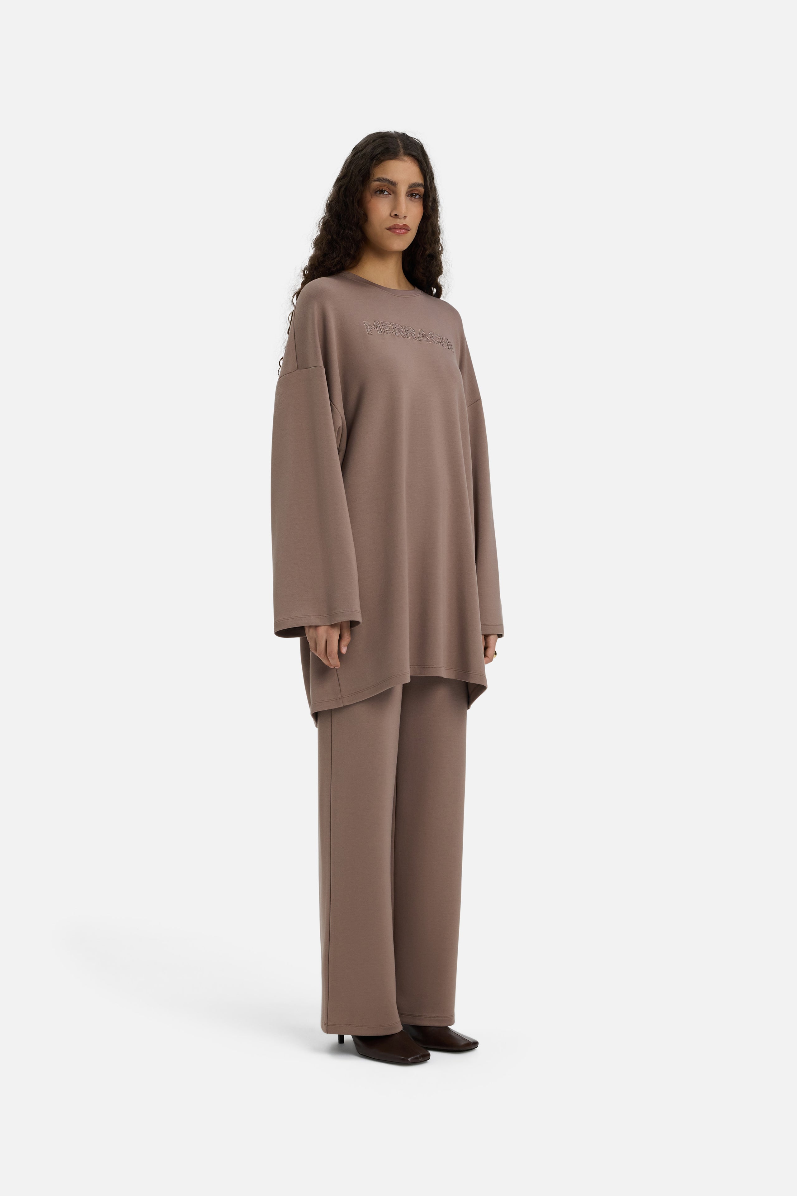 Model wearing taupe MERRACHI pants, front view